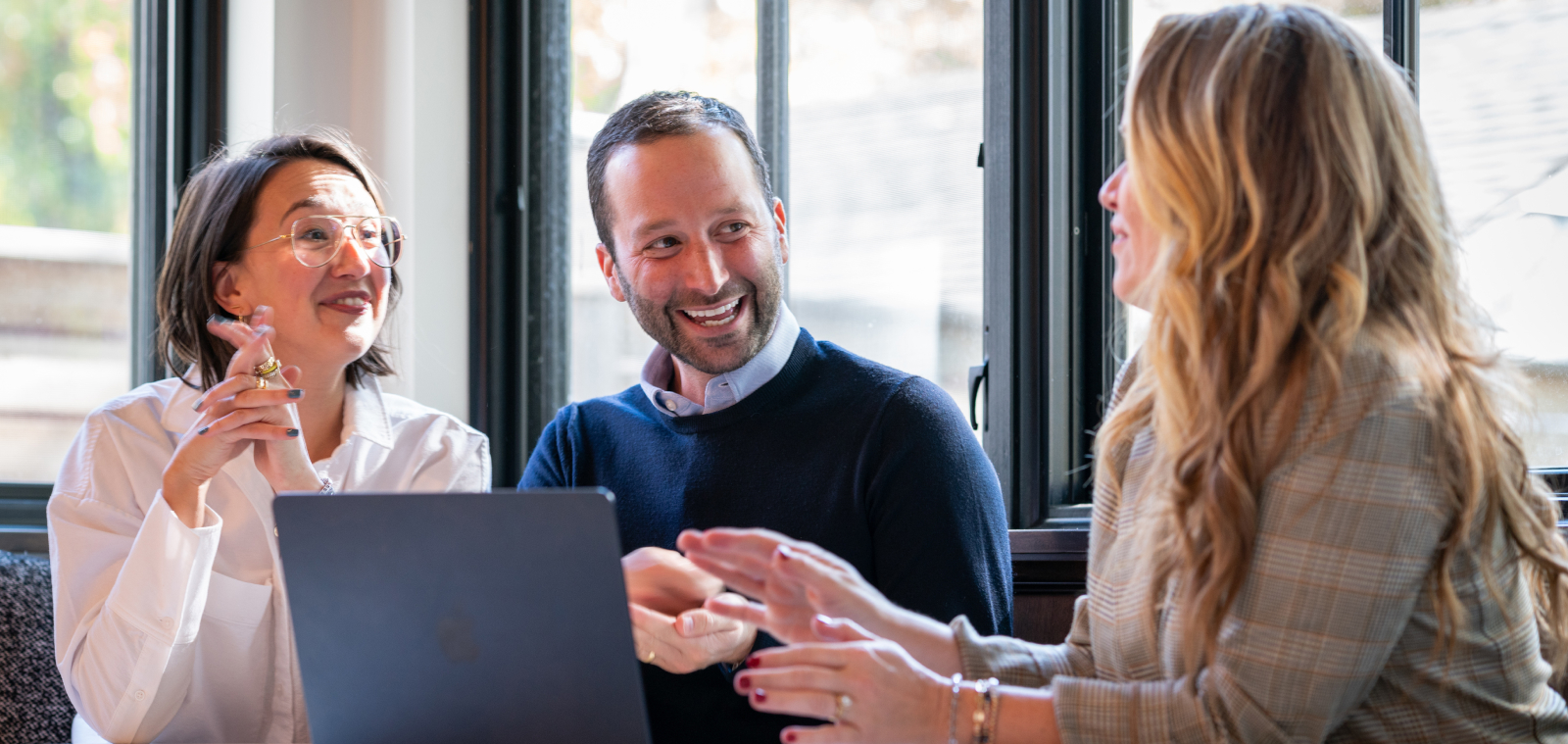 Construction Project Manager Software 70 Three people having a discussion around a laptop